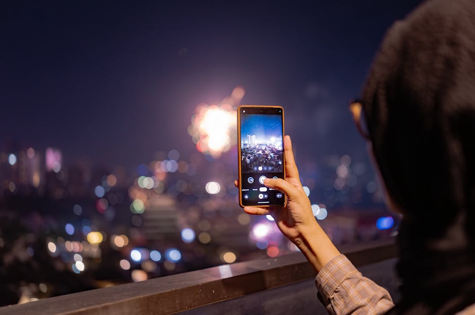 A person photographing vibrant fireworks in Jakarta at night with a smartphone Urban cityscape in the background